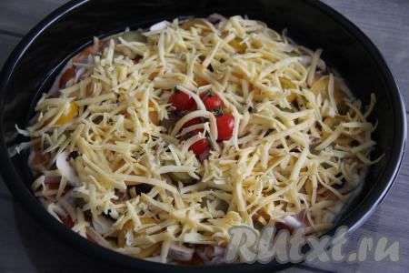 Пиццу посыпать натёртым сыром и поставить её в хорошо прогретую духовку.