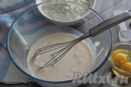 В миску влить ряженку и добавить соду, перемешать смесь венчиком и оставить минут на 5 (за это время сода погасится в ряженке).