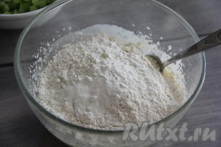 А затем всыпать разрыхлитель, частями начать добавлять просеянную муку, перемешивая тесто столовой ложкой.&nbsp;