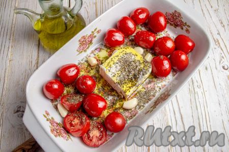 Добавьте в форму очищенные зубчики чеснока, присыпьте сушёным орегано и полейте сверху оливковым маслом. Поставьте форму в духовку, запекайте черри с фетой минут 15-20 при температуре 200 градусов.