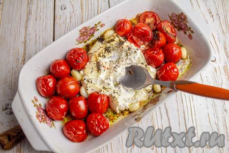 Достаньте форму с запечёнными сыром и черри. Помните помидоры ложкой и смешайте их с запечённым сыром.