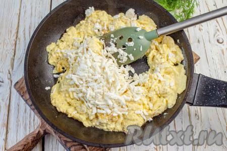 Когда омлет будет готов, добавьте натёртую на крупной тёрке брынзу, перемешайте и попробуйте на вкус, если необходимо, то приправьте солью и молотым чёрным перцем.