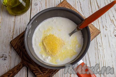 В закипевшую смесь тонкой струйкой всыпьте частями кукурузную крупу, при этом интенсивно и постоянно перемешивая.