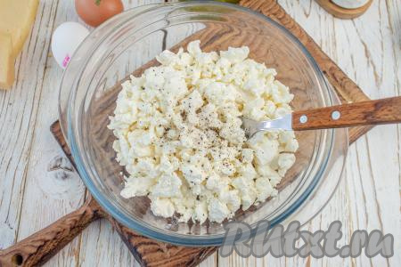В подходящую посуду выложите творог, посолите и поперчите по вкусу.