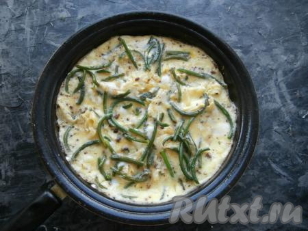 Яичницу с чесночными стрелками готовить на небольшом огне под прикрытой крышкой минуты 3-4. Яйца должны полностью "свернуться", в процессе жарки их можно немного подмешивать от краёв к центру сковороды.