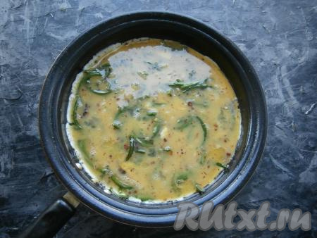 Чесночные стрелки залить смесью яиц и специй.