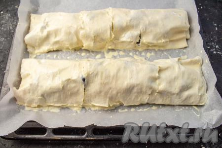 Подготовленные рулеты переложите на противень, застеленный пергаментом. Яичный желток смешайте с молоком, получившейся смесью смажьте рулеты и поставьте в заранее разогретую до 200 градусов духовку минут на 20.