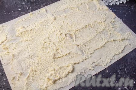 Расстелите лист лаваша на столе, смажьте его половиной творожной массы (не забывайте, что мы будем готовить 2 рулета из лаваша с начинкой из творога и вишни). Творожную массу равномерно распределите по лавашу.