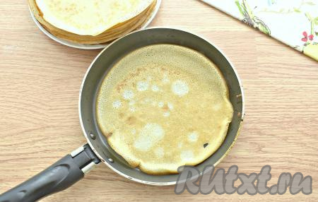 Приступаем к выпечке блинчиков. Сковороду один раз смазываем маслом. Очень хорошо разогреваем поверхность сковороды. Зачерпываем половником тесто и выливаем на сковороду, равномерно распределяя по дну сковородки. Жарим блинчик с каждой стороны, примерно, по 50 секунд на огне чуть выше среднего, затем перекладываем на тарелку. Аналогично готовим все блины, периодически перемешивая блинное тесто в миске. Всего у меня получилось 15 блинов (я жарила блинчики на сковороде диаметром 18 сантиметров).