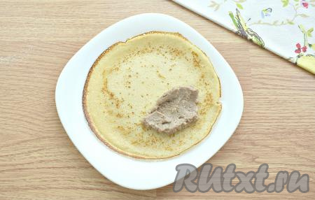 Когда и блины, и начинка будут тёплыми, можно приступить к фаршировке. На одну сторону блина кладём по столовой ложке начинки. Подворачиваем края блина с трёх сторон на начинку из ливерной колбасы, а затем сворачиваем рулетом, начиная со стороны с начинкой.