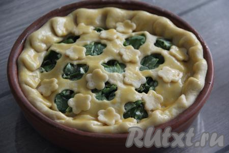 Поверх теста я в качестве украшения разместила вырезанные цветочки. Смазать верх пирога взбитым желтком.