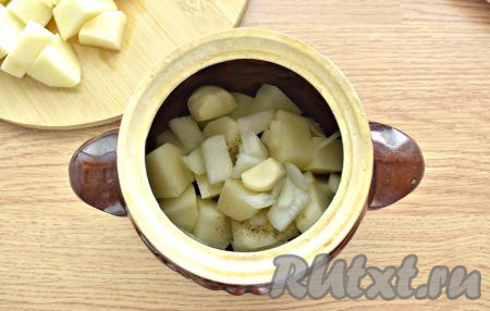 На картошку выкладываем целые зубчики чеснока и половину нарезанного лука.