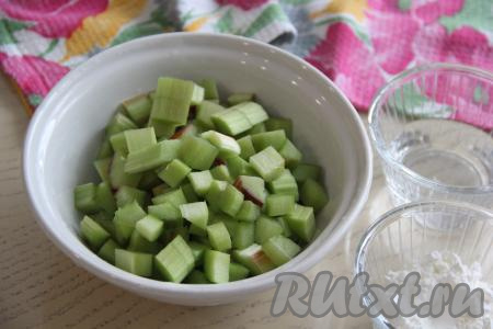Стебли ревеня вымыть, снять тонкую плёночку, покрывающую всю поверхность каждого стебля. Нарезать подготовленные стебли на кубики.