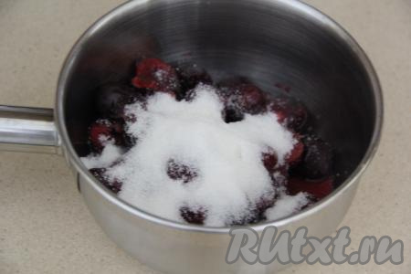 Вытащить чизкейк из духовки и полностью остудить. Пока чизкейк остывает, можно приготовить начинку из черешни. В сотейнике соединить очищенную от косточек черешню и сахар.