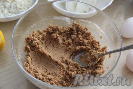 Соединить в миске растопленное масло и крошку печенья, перемешать ложкой.