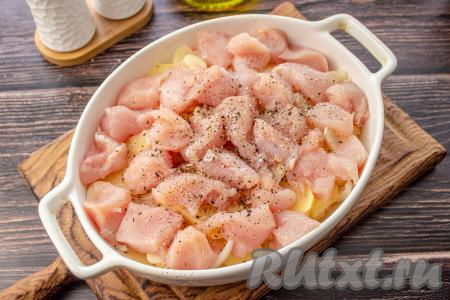 Вымойте куриное филе и нарежьте его на небольшие кусочки, разложите поверх картофеля. Присолите и поперчите.