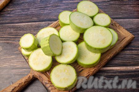 Для этого блюда нужно брать молоденькие кабачки с тонкой кожурой и мелкими семечками. Кожуру с молодых кабачков можно не снимать. Кабачки промойте, нарежьте на кружочки толщиной 10-15 миллиметров.