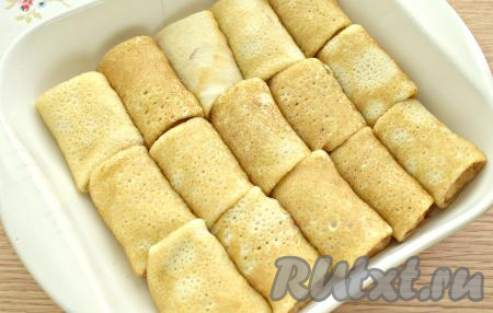 Аналогично сворачиваем все блины, фаршированные сыром и ветчиной, конвертиком и выкладываем их в форму для запекания, ставим в разогретую до 200 градусов духовку на 10 минут. За это время сыр внутри блинчиков расплавится. Можно также перед подачей обжарить блинчики с двух сторон на сковороде, смазанной сливочным маслом.