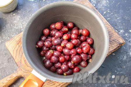 У свежего крыжовника при помощи ножниц срежьте хвостики с двух сторон. Выложите подготовленные ягоды в ковш.