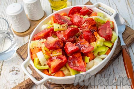 Влейте в форму с овощами растительное масло, добавьте молотую паприку, поперчите и посолите, аккуратно перемешайте.