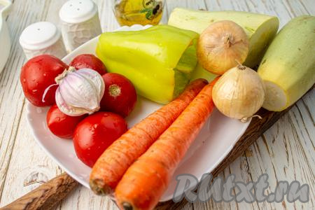 Подготовьте необходимые продукты для приготовления кабачков, тушёных с овощами в духовке. Луковицы, зубчики чеснока и морковь очистите. Удалите семена и плодоножку из болгарского перца.