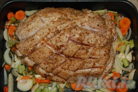 Взять окорок (задняя часть ноги), аккуратно снять кожу, по всей поверхности сделать глубокие надрезы в виде сеточки. В глубокий противень налить растительное масло, положить в это масло все специи, включая соль и перец, травы. В этой смеси как следует искупать окорок, чтобы он весь был покрыт этой смесью. Переложить окорок на блюдо, а в противень выложить крупно нарезанные морковь, лук и сельдерей. На овощи водрузить окорок.