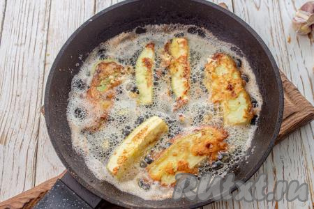 В сковороде нагрейте растительное масло, выложите кабачки, покрытые кляром. Жарьте на среднем огне по 2-2,5 минуты с каждой стороны. Обжаренные кабачки переложите на бумажное полотенце для удаления лишнего масла. Постепенно пожарьте на сковороде все кабачки, покрытые кефирным кляром.