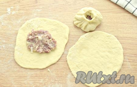 Теперь каждый кусочек дрожжевого теста раскатываем в лепёшку толщиной 3-4 миллиметра. В центр каждой лепёшки кладём по 1 полной столовкой ложке фарша. Поднимаем края каждой заготовки к центру, собирая складочками. Получается перемяч, как на фото, с отверстием в центре.