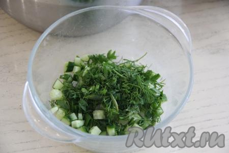 Огурец, нарезанный на маленькие кубики, и мелко нарезанную зелень выложить в миску, перемешать.