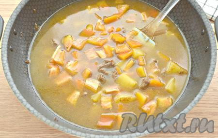 Перец промываем, очищаем от семян, нарезаем на небольшие кусочки, добавляем на сковороду, вливаем около 700 миллилитров кипячёной воды, доводим до кипения, если нужно, досаливаем. Сковороду накрываем крышкой, тушим суп-гуляш из говядины на минимальном огне 15 минут.