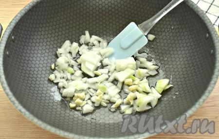 Очищаем репчатый лук, зубчики чеснока и морковку. Нарезаем лук на кусочки, чеснок мелко рубим. В сковороде разогреваем растительное масло и выкладываем нарезанные чеснок и лук, обжариваем на умеренном огне, периодически перемешивая, 5-6 минут. Лук должен приобрести золотистый оттенок.