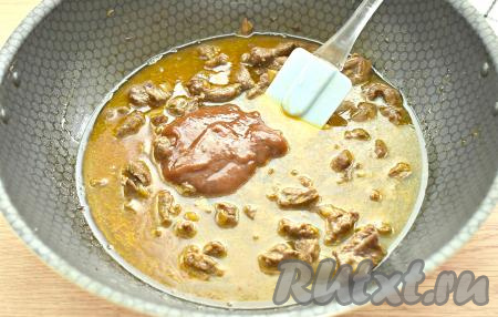 К обжаренной говядине с луком выкладываем томатный соус, вливаем, примерно, 250 миллилитров кипячёной воды, перемешиваем, доводим воду до кипения и уменьшаем огонь до минимального. Сковороду накрываем крышкой, тушим мясо около 1,5-2 часов. При необходимости в процессе тушения вливаем ещё немного воды в сковороду.