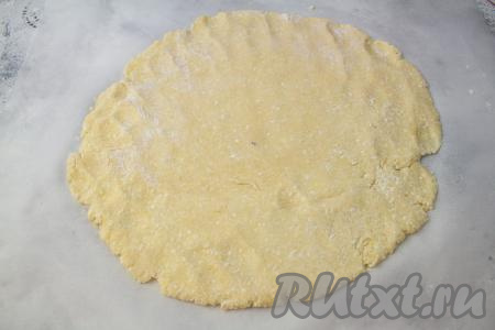 На листе пергамента раскатайте тесто в круг диаметром 26-30 сантиметров, толщиной 0,5-0,7 сантиметра. Старайтесь серединку круга оставить немного толще, чем края.