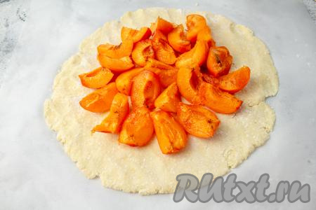 Абрикосы промойте, обсушите, разделите на 2-4 части (в зависимости от их размера) и выложите в середину теста, отступая 3-4 сантиметра от краёв.