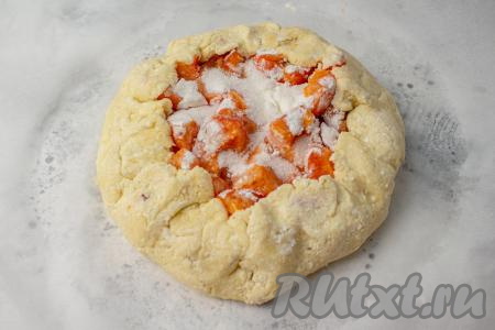 Приподнимите края круга к верху и положите на начинку, формируя галету с абрикосами, как на фото. Переложите галету вместе с пергаментом на противень (или в форму для выпечки), отправьте в заранее разогретую духовку. Выпекайте 15-20 минут при температуре 190-200 градусов.