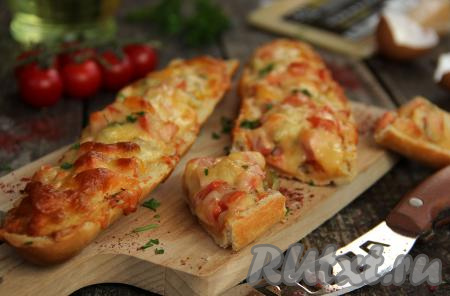 Аппетитную, сытную пиццу из багета достать из духовки, разрезать на кусочки и можно подавать к столу.