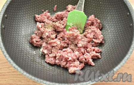 Мясной фарш выкладываем к обжаренному луку, по вкусу его солим и перчим.