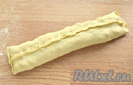 Пласт с фаршем сворачиваем в рулет. Скрепляем края получившегося рулета.