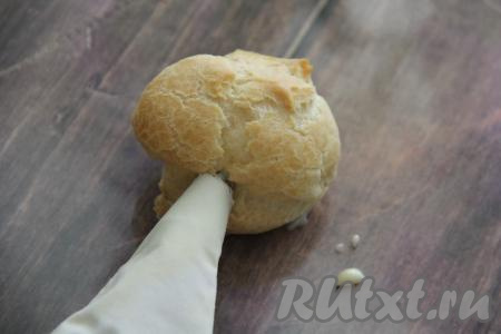 Готовый заварной крем переложить в кулинарный мешок. Наполнить остывшие профитроли кремом.