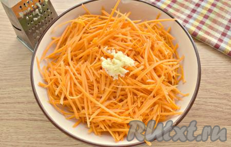 Очищенные зубчики чеснока натираем на мелкой тёрке (или пропускаем через пресс) и выкладываем в центр поверх морковки.