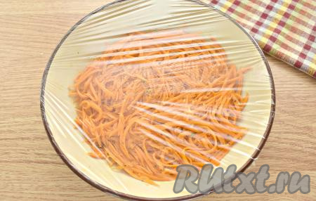 Снова тщательно перемешиваем морковь. Прижимаем её ложкой в миске. Затягиваем миску с морковкой пищевой плёнкой. Отправляем морковь мариноваться в холодильник на 5-6 часов (можно оставить мариноваться и на более длительное время).