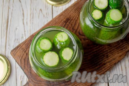 Кипящей водой снова залейте огурцы, прикройте крышками и оставьте на минут 15.&nbsp;