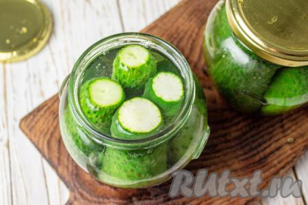В чайнике вскипятите воду. В банки с огурчиками влейте кипящую воду, заполняя баночки до самого верха. Банки сразу прикройте крышками и оставьте минут на 10-15.