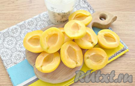 Разрезаем абрикосы пополам и удаляем косточки.