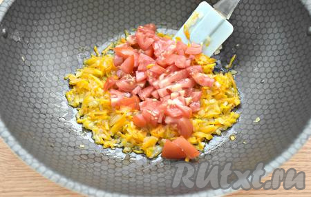 Помидор моем, нарезаем на кубики, выкладываем к обжаренным овощам. Обжариваем лук с помидорами и морковью минут 5, периодически помешивая.&nbsp;