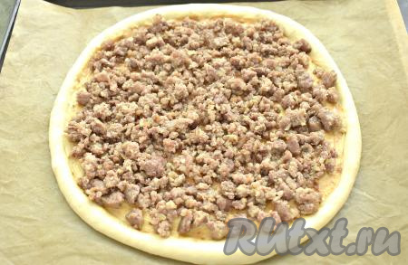 Выкладываем на основание пиццы треть обжаренного мясного фарша, равномерно распределяя его по всей поверхности.