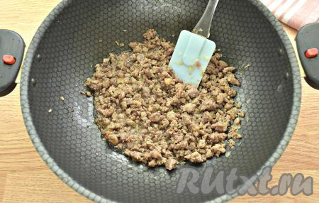 Добавляем мясной фарш, по вкусу солим и перчим. Обжариваем фарш вместе с луком 10 минут, в процессе разбиваем мясные кусочки лопаточкой. Готовую мясную начинку остужаем.