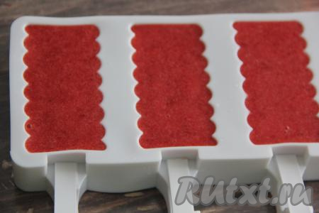 В форму для мороженого вставить палочки. Я использовала силиконовую форму, купленную на Ozon. Разлить клубничную массу по формочкам (у меня получилось 3 формочки) и отправить в морозилку до полного застывания.