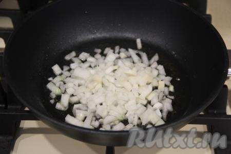Почистить, мелко нарезать лук и выложить в сковороду, заранее немного прогретую с растительным маслом. Лук обжаривать на среднем огне, помешивая, минуты 2-3.