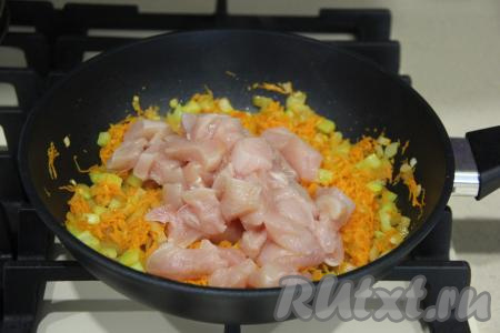 Куриное мясо нарезать на кубики и добавить в сковороду с овощами.